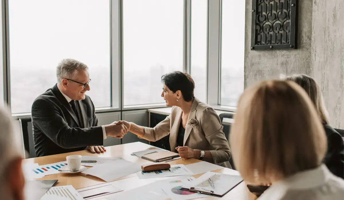 Two business representatives agreeing to a merger after reviewing insurance data